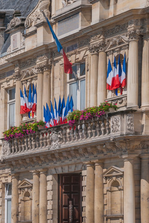 French flags flying over the entrance to the city hall in Reims for Bastille Day.のeditorial素材