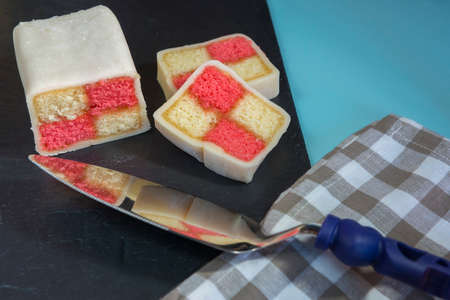 Closeup of a Battenberg cake with a cake slice in the foregroundの写真素材