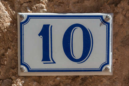 Blue and white number 10 ceramic plaque on a house wallの写真素材