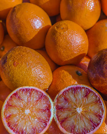 Fresh local blood oranges on display with one cut through displaying the juicy cross sectionの写真素材