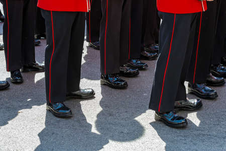 British soldiers wearing red ceremonial uniforms lined up with polished bootsの写真素材