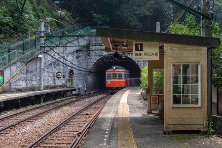 A Hakone Tozan line train comes out of the tunnel mouth at Tonosawa stationのeditorial素材