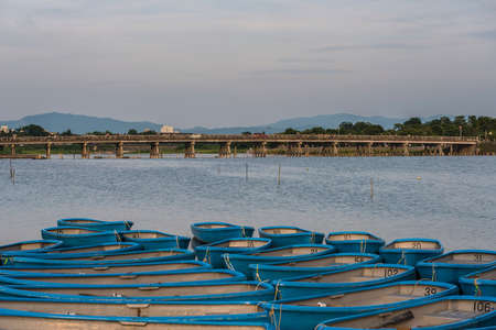 The Togetsukyo Bridge across the Katsura River in Arashiyama with rowing boats moored in the foregroundの写真素材