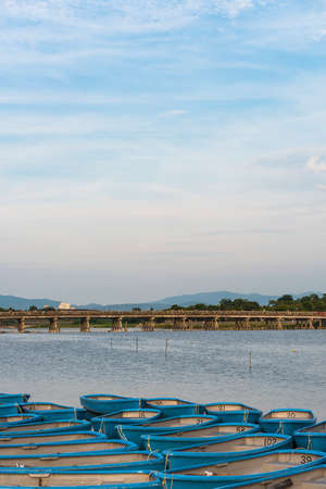 The Togetsukyo Bridge across the Katsura River in Arashiyama with rowing boats moored in the foregroundの写真素材