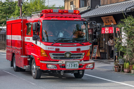 A Japanese fire engine drives along an urban street