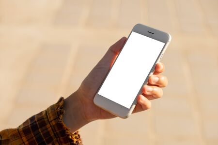 Woman hand holding and using smart phone with blank screen at outdoor backgroundの写真素材