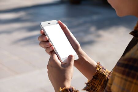 Woman hand holding and using smart phone with blank screenの写真素材