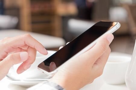 Women holding and touch mobile phone in coffee cafe