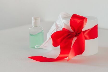 toilet paper with a red bow on a white background. Sanitizer. White medical maskの写真素材