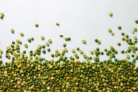 Green peas beautifully laid out on a white background. Top view and copy space. Vegetarian food. Unprepared.の写真素材