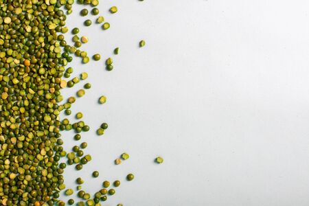 Green peas beautifully laid out on a white background. Top view and copy space. Vegetarian food. Unprepared.の写真素材