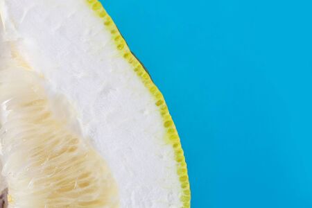 sliced pomelo bright yellow green on a blue background. isolated. copy space