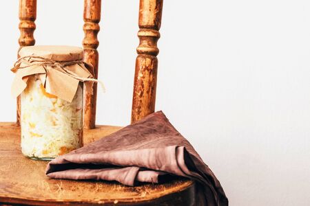 fermented vegetables in transparent glass jars covered with paper from recycled materials. cabbage. On a wooden vintage background on a white background . copy space. textileの写真素材