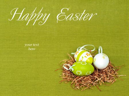 Easter composition: nest with three colorful eggs on a green flax background (with space for text) の写真素材