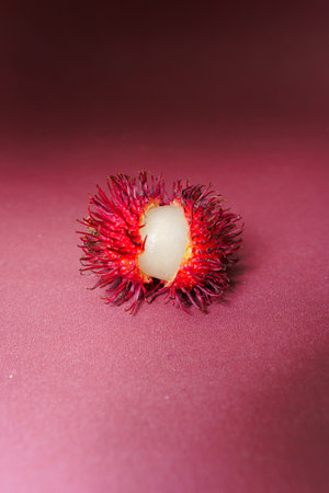 Rambutan on a red background. Rambutan is a species of tropical fruit.