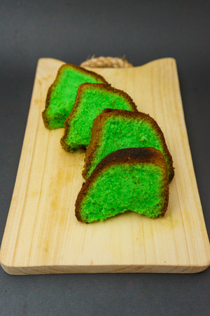 Green tea cake on wooden board, black background, selective focus.の写真素材