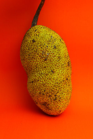 Ripe yellow pear on a red background, close-up.