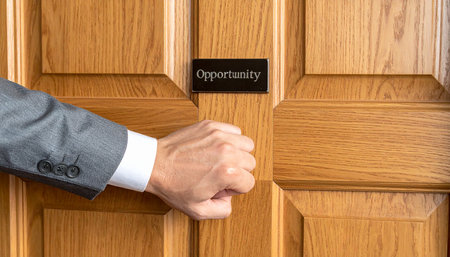 Businessman's hand opening a wooden door with the word opportunity.の素材