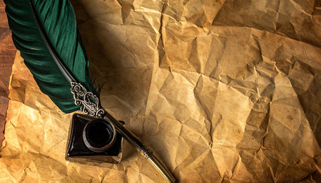 Quill pen and inkwell on old paper background with copy spaceの素材