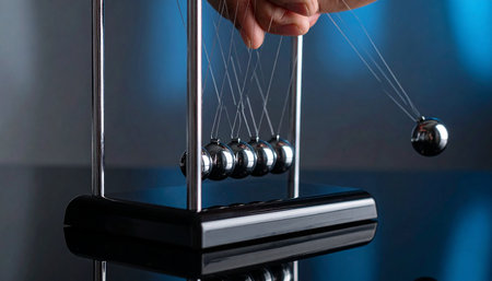 Close-up of newton's cradle on the table with handの素材