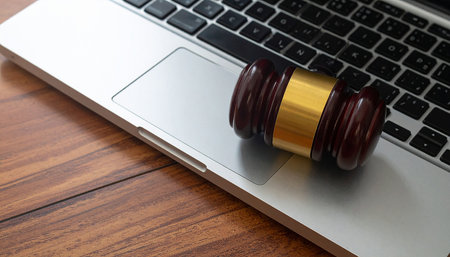 Gavel on laptop keyboard. Law and justice concept. Wooden background.の素材