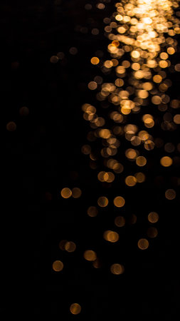 Lights showing golden bokeh lights on black background abstract background. High resolution image suitable...の素材