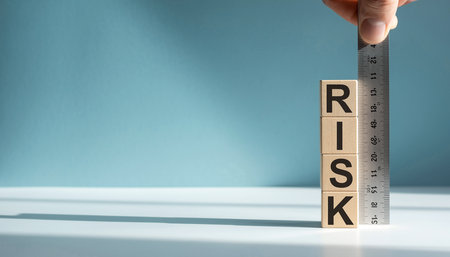 A hand holds a ruler measuring stacked wooden blocks spelling the word RISK. Clear details and vibrant colors...の素材