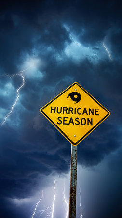 Yellow diamond warning sign for hurricane season against a dark stormy sky with lightning.の素材