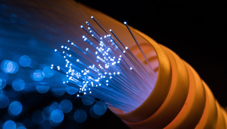 Close up of illuminated blue fiber optic strands emerging from a yellow protective tube.の素材