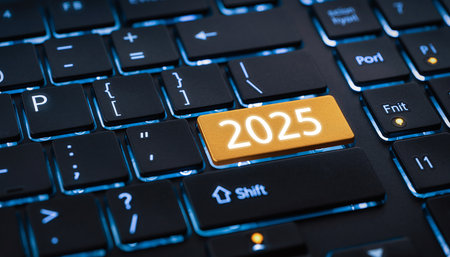 Close up of a keyboard with a golden key labeled 2025, illuminated by blue backlighting.の素材