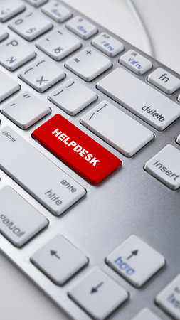 A bright red "Helpdesk" key is the focal point of this computer keyboard close-upの素材