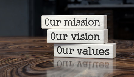 Stacked wooden blocks with text Our mission Our vision Our values on a wooden tableの素材