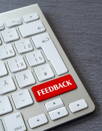 A computer keyboard with a bright red button labeled "FEEDBACK" Clear details and vibrant colors enhance visu...の素材