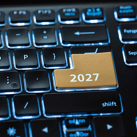 A close-up of a backlit keyboard with the number 2027 on a golden key. Clear details and vibrant colors enhan...の素材