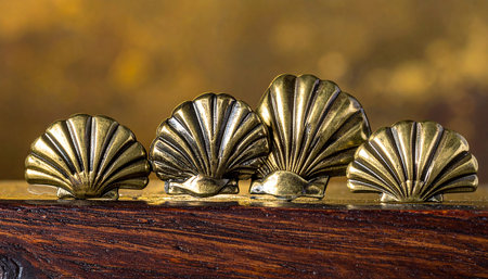 golden seashells on a wooden background, close-upの素材