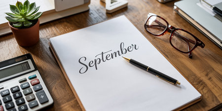 Pencil on paper with september word and glasses on tableの素材