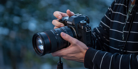Photographer with professional camera on blurred background. Focus on camera.の素材