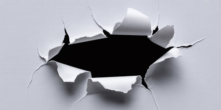 Hole ripped in white paper with black space for your message.の素材