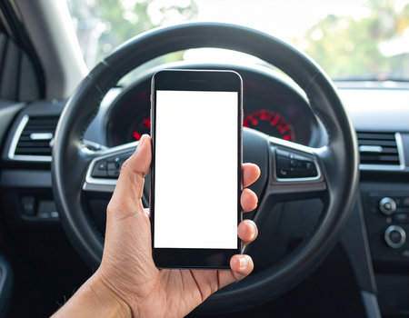 Close up of hand holding mobile phone with blank screen while driving carの素材