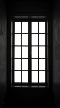 Silhouette of a window in a dark room with light and shadowの素材