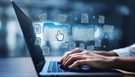 Hands of businesswoman typing on laptop keyboard on blurry office interior backgroundの素材