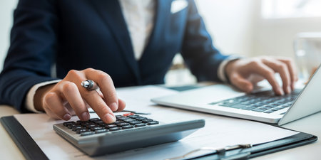 Accountant checking financial statement or counting by calculator income for tax form. Businessman hand working with finances about cost in office.の素材