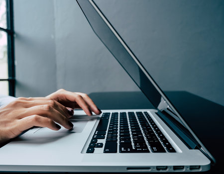 Close up of woman hands typing on laptop keyboard at home office.の素材