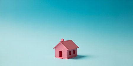 Small pink house on a blue background. The concept of buying a house.の素材