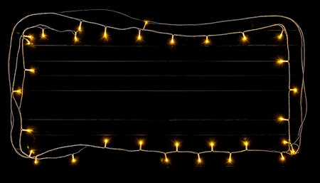 Christmas lights garland on a black background. Place for text.の素材