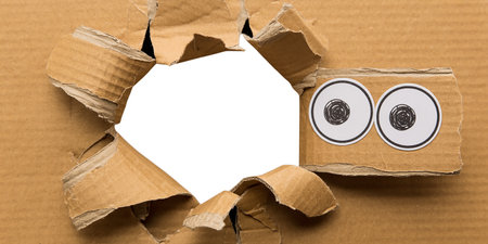 Hole in cardboard with two contact lenses on a white background.の素材