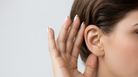 Close up view of young woman using modern digital hearing aid. deafness conceptの素材