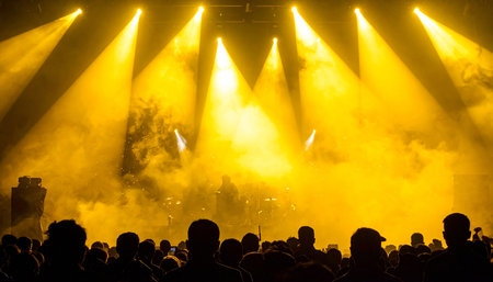 Stage lights and crowd of people at a music festival or concert.の素材