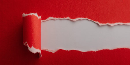 Torn paper with space for your message on a red background.の素材