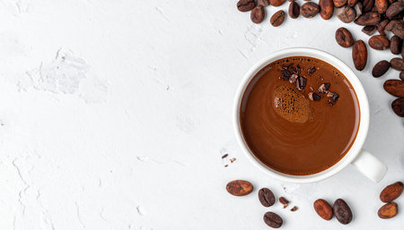 Cup of hot chocolate with cocoa beans on white background, top viewの素材